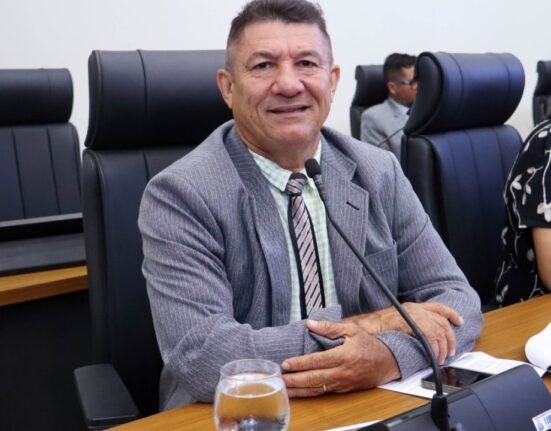 Foto de frente do vereador Márcios Reis olhando pra câmera a partir de seu assento no plenário da Câmara Municipal.